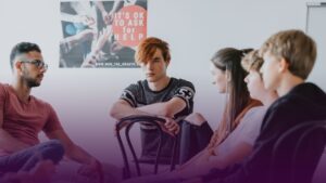 A group of young people sitting in a group. A poster behind says 'it's ok to ask for help'