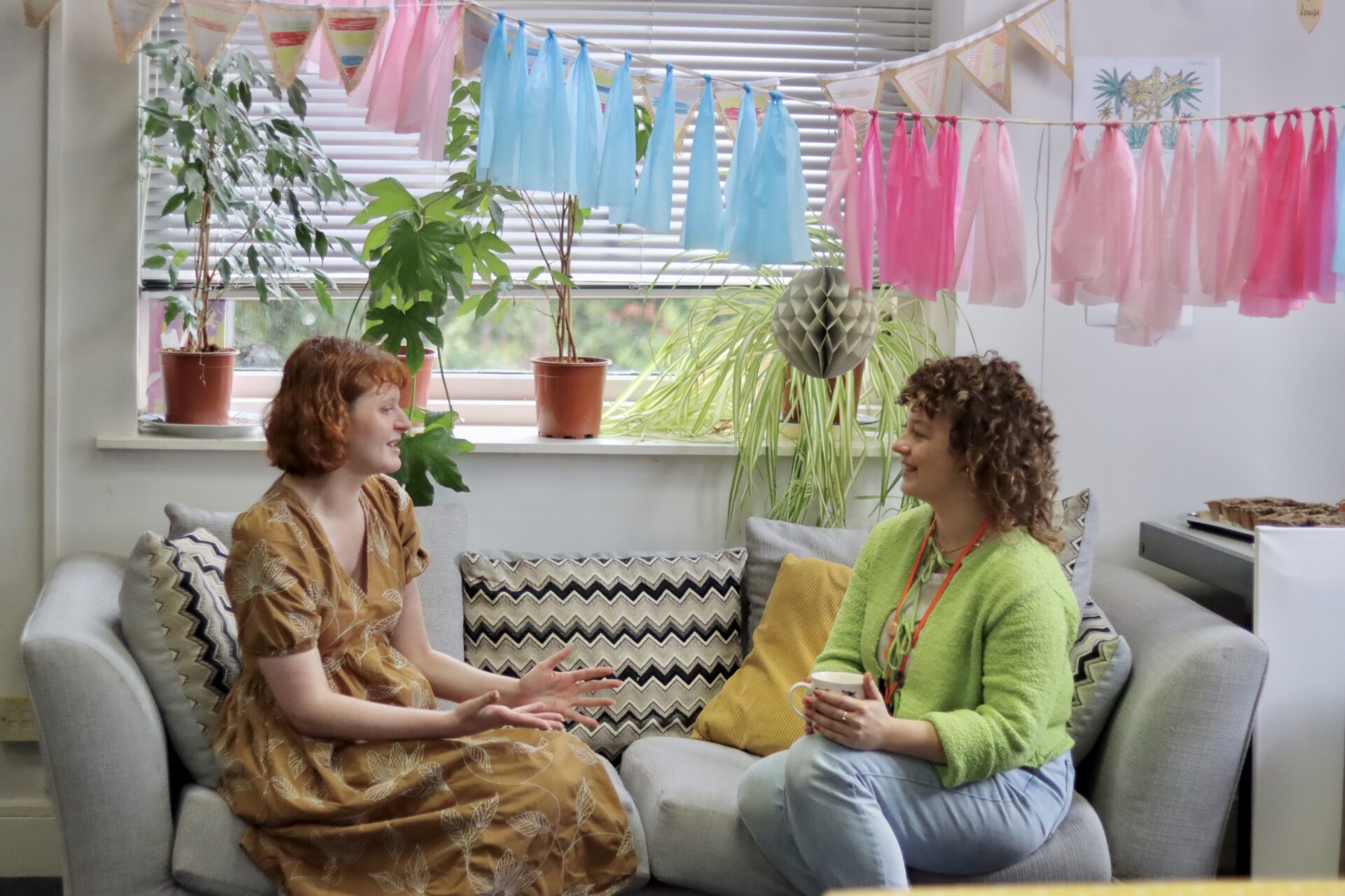 Photos of 2 people sitting on a sofa, talking and smiling.