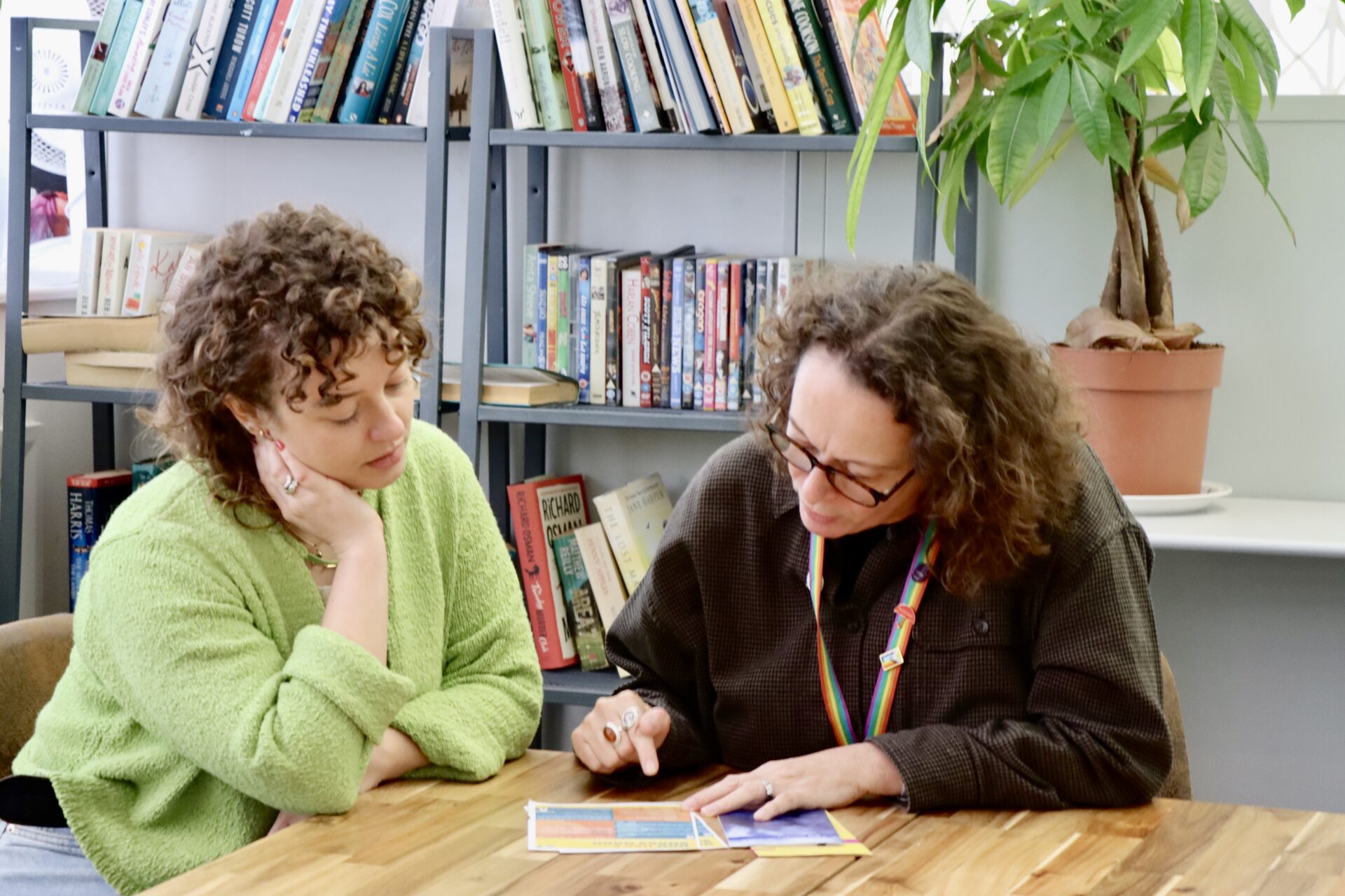 Photo of two people looking intently at a booklet together.